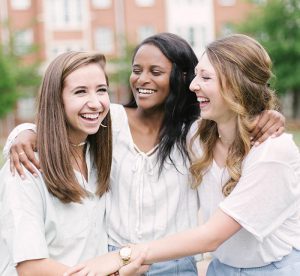 girls smiling and holding hands