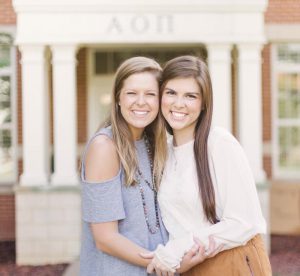 girls smiling in front of AOII house