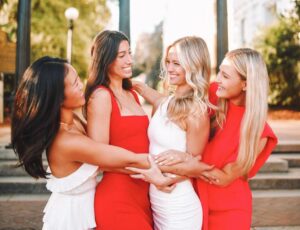members wearing red and white dresses